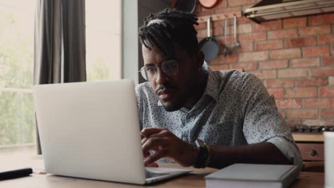 美国黑人商人自由职业者在现代触摸屏笔记本电脑上浏览网页