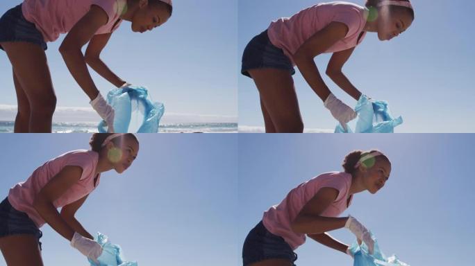 非裔美国妇女在海滩上收集塑料垃圾