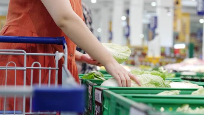 女人在超市选择绿色蔬菜