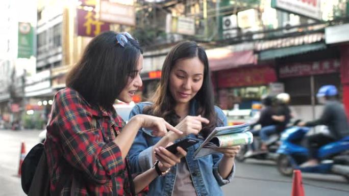 两个亚洲旅游朋友在城市指南中使用地图