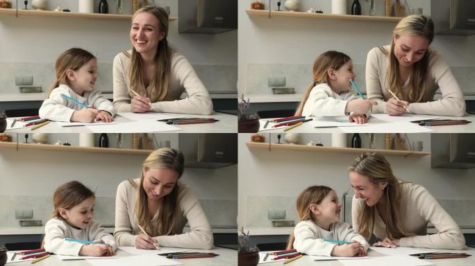 女人她可爱的小女儿用彩色铅笔画画