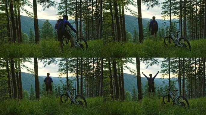 SLO MO Mountain骑自行车的人停下来从森林中的林间空地上欣赏山谷的美景