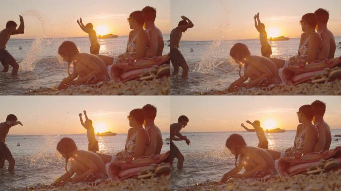时间扭曲家庭有三个孩子在日落时在海滩上放松