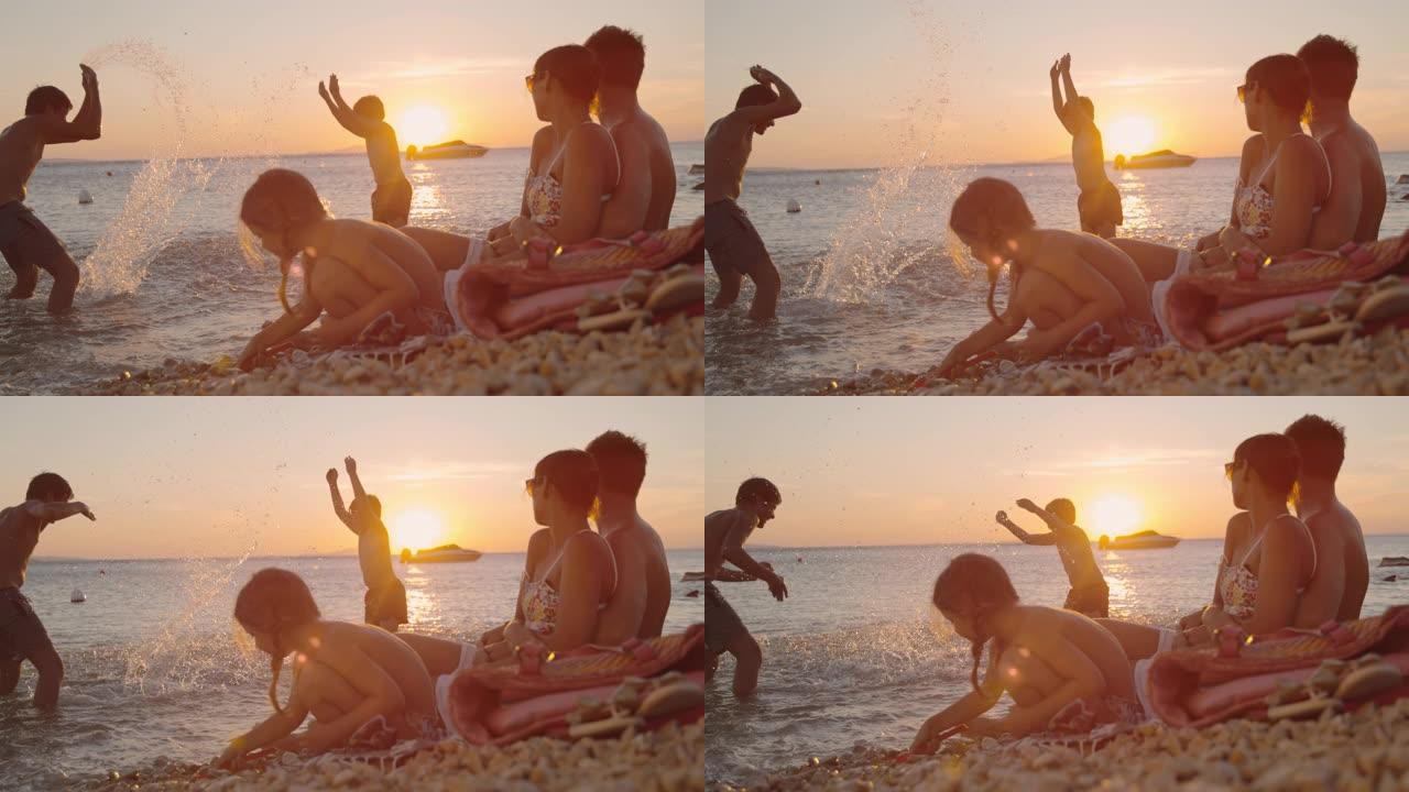 时间扭曲家庭有三个孩子在日落时在海滩上放松