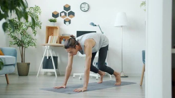 一个人在公寓里独自做复杂的瑜伽体式训练的慢动作