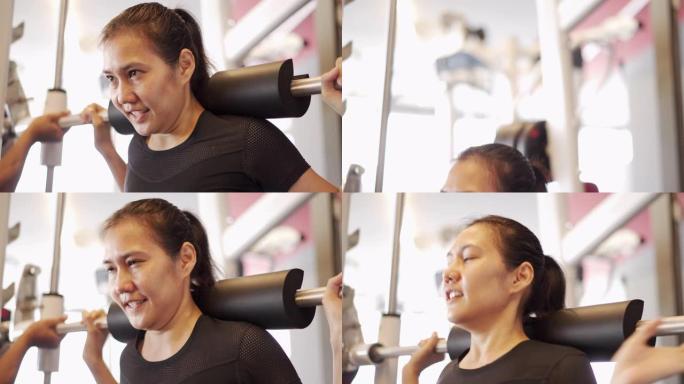 亚洲女子在健身房腿部锻炼时用杠铃蹲下