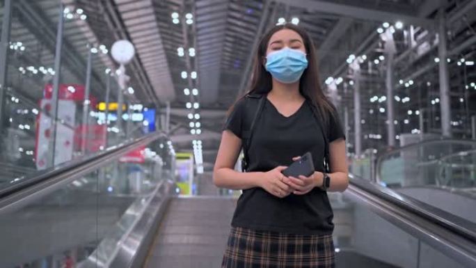 宽幅镜头: 亚洲妇女在等待在机场度假时正在看手机