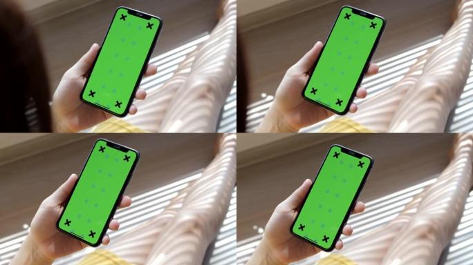使用带有绿色色度键屏幕的智能手机的女人