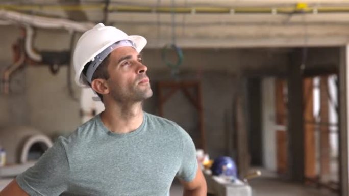 有思想的巴西男子在一个戴着安全帽的建筑工地看着天梦