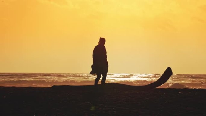 意大利撒丁岛日落时在海滩上独自行走的女人的景色。