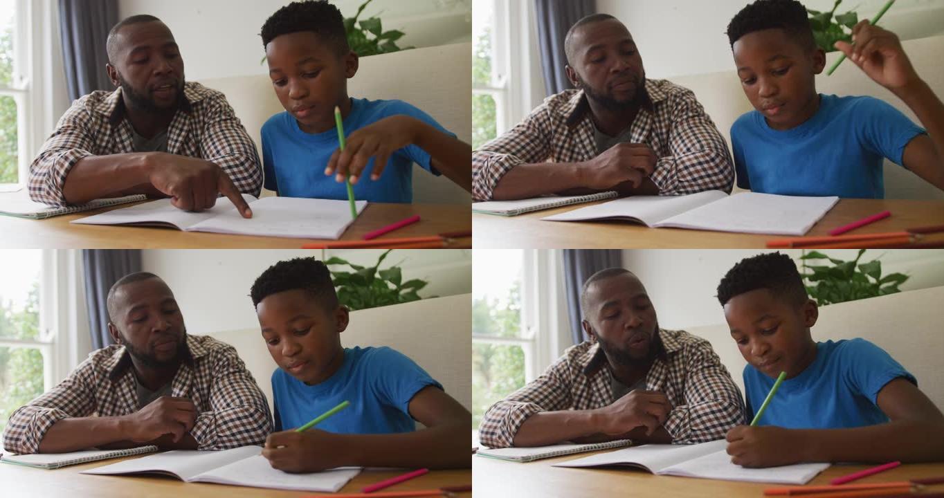 快乐的非洲裔美国父亲坐在厨房的桌子上，帮助儿子完成学业