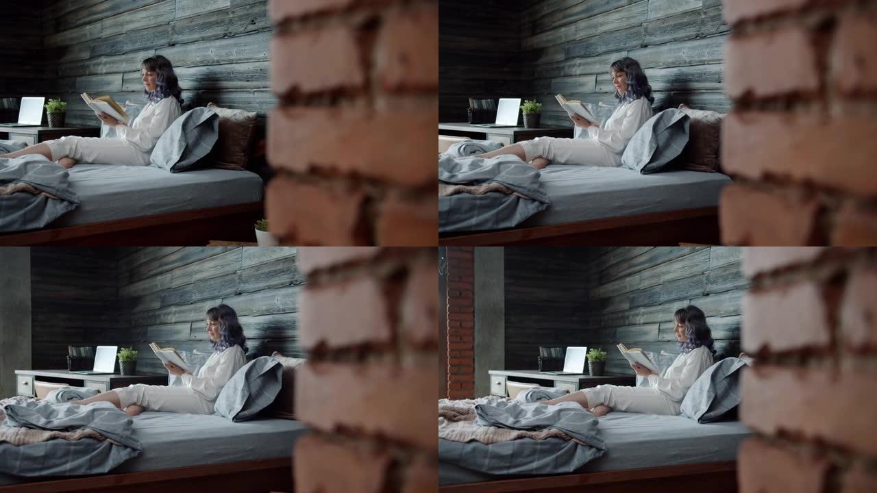 穿着睡衣的迷人女孩独自在家舒适的床上看书
