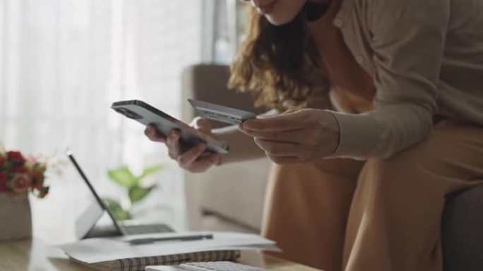 女性在家庭客厅的智能手机上在线购物
