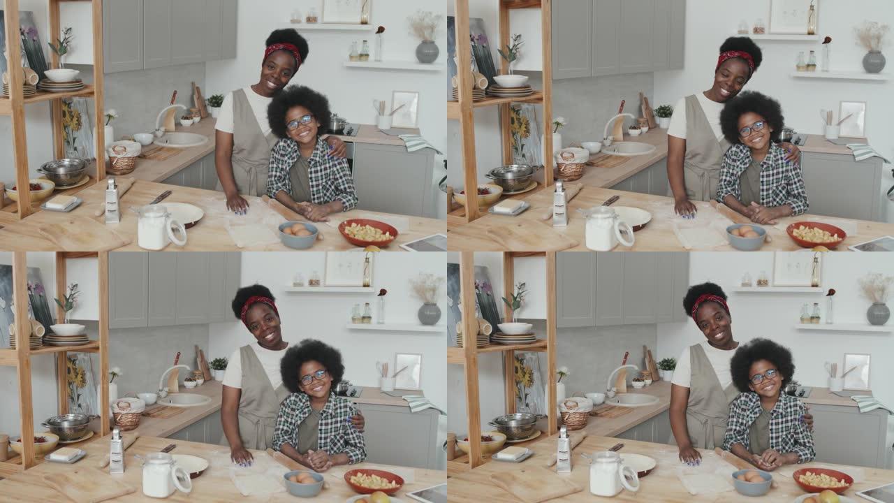 厨房里微笑的非洲裔美国母亲和儿子的肖像