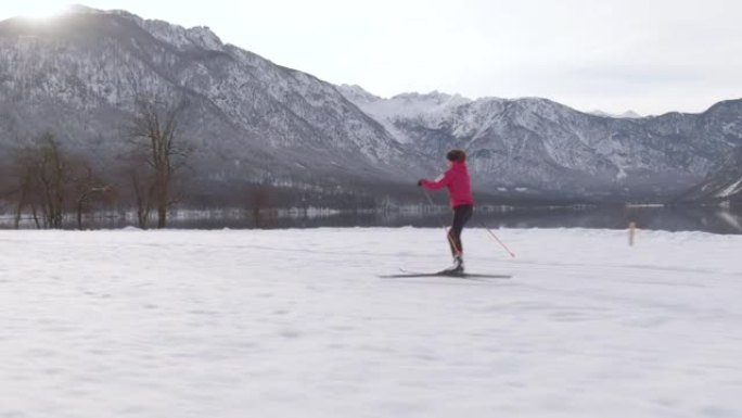 空中: 在阳光明媚的冬日，一名北欧女子滑雪者训练的无人机拍摄。