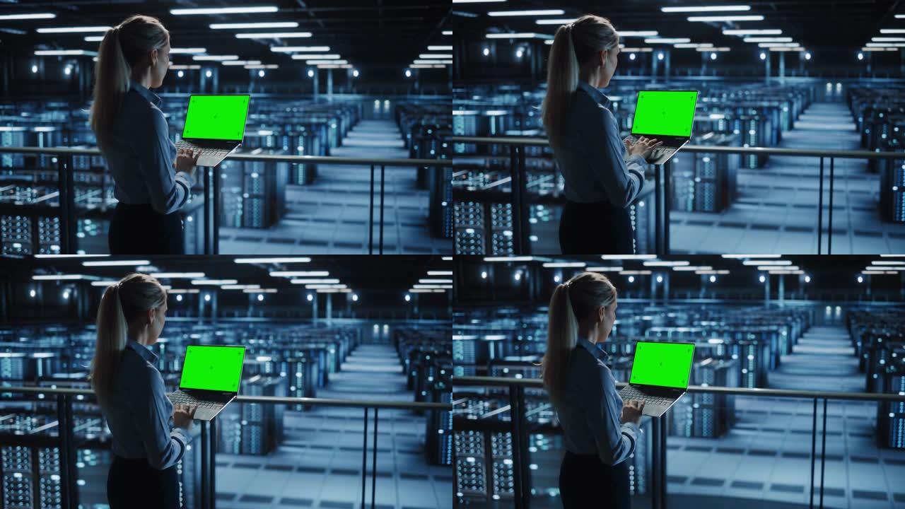 在数据中心使用色度键笔记本电脑的女性It专家。大服务器场云计算设施，维护工程师与绿屏计算机合作。肩部
