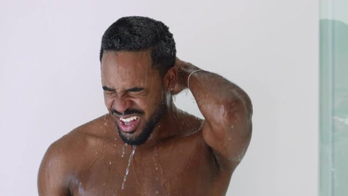 年轻英俊的非裔美国人正在用洗发水擦洗头发。