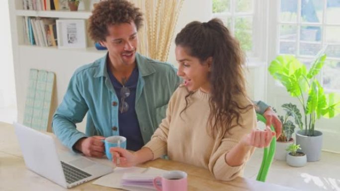 夫妇在家中使用笔记本电脑检查账单和家庭财务准备在线商店的商业计划-慢动作拍摄