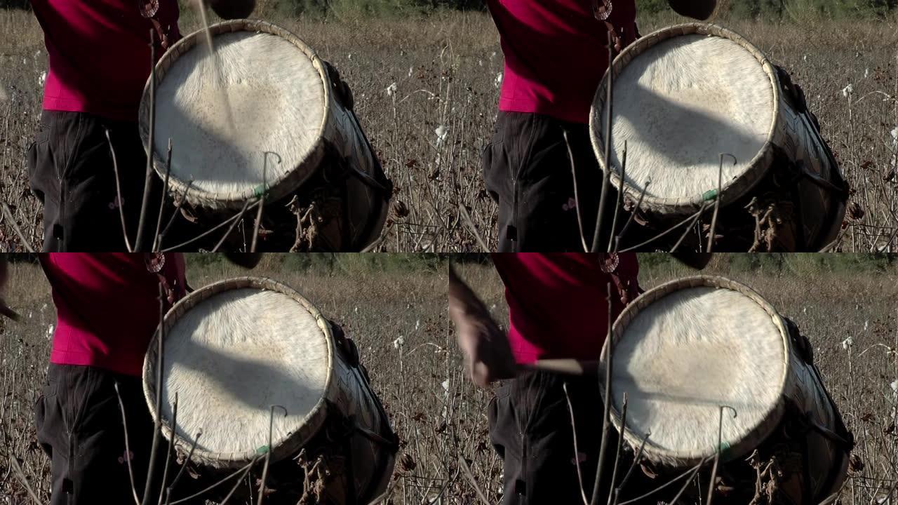 一名男子演奏 “Bombo Leguero”，这是一种用木头和动物皮革制成的阿根廷鼓，用于当地传统民