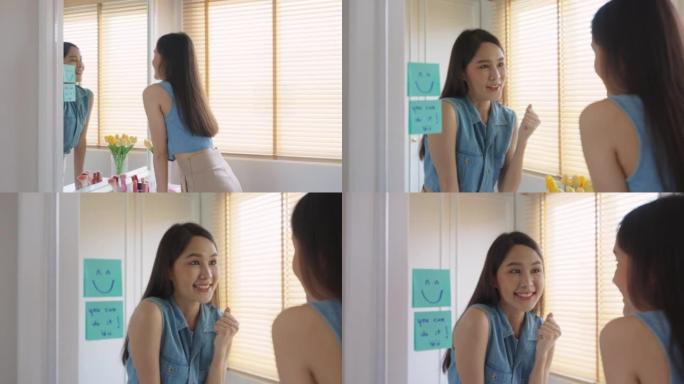 亚洲女性在镜子前用微笑便利贴自言自语。