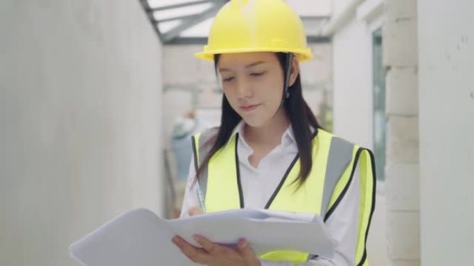 女建筑工程师在建筑工地上看蓝图的肖像