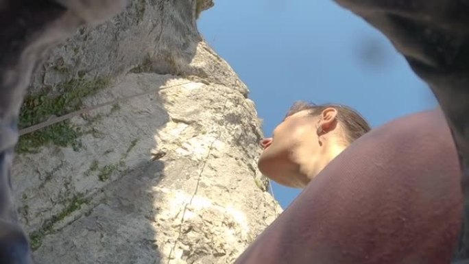 自下而上: 女性登山者在斯洛文尼亚攀岩时分析岩石墙。