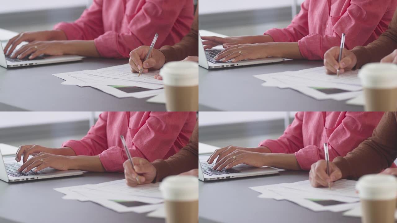 办公室里的商人和女商人在笔记本电脑和设计上合作的特写镜头