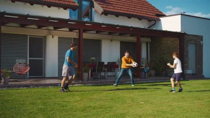 SLO MO父亲在后院玩球时将球传给了他的两个儿子。