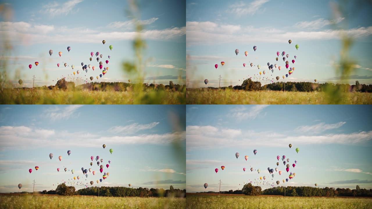 充满活力的热气球在乡村田野上阳光明媚，田园诗般的天空中飞行
