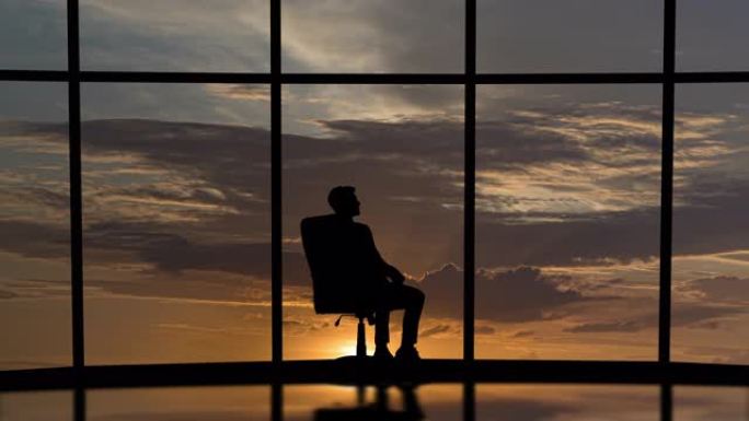 商人在美丽的日落天空背景上的椅子上旋转