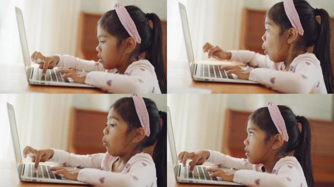小女孩在家学习在笔记本电脑上打字。儿童在虚拟课堂期间在线工作和互动。学龄前儿童享受使用现代技术的惊人