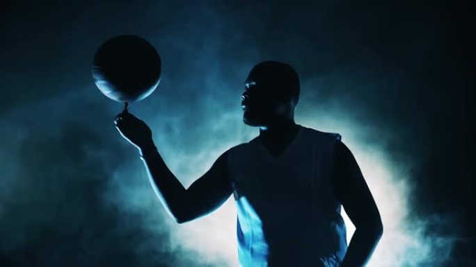 篮球运动员在烟雾中旋转手指上的球