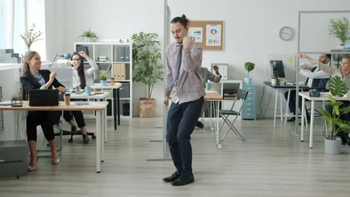 有创造力的人在办公室表演现代舞，而员工在背景中玩得开心