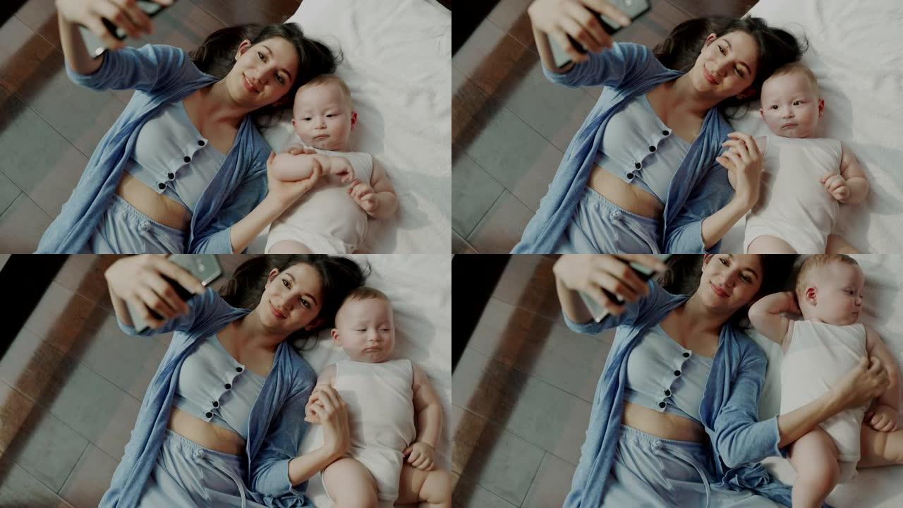妈妈和她的孩子上床了。用手机在床上互相拍照。它代表着母亲和婴儿之间的爱和温暖。谁想在一起有一张令人印
