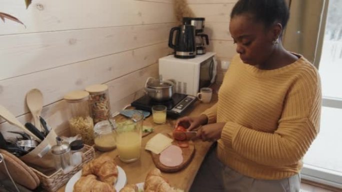 黑人妇女准备饭菜牛角包家庭早餐