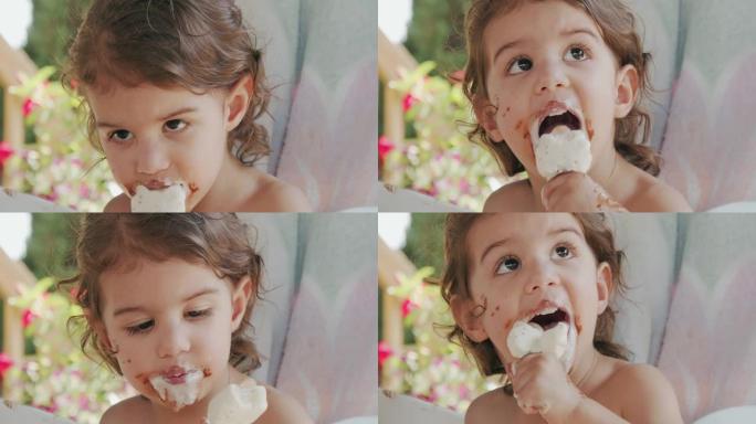 可爱的蹒跚学步的女孩吃冰淇淋，弄得一团糟。