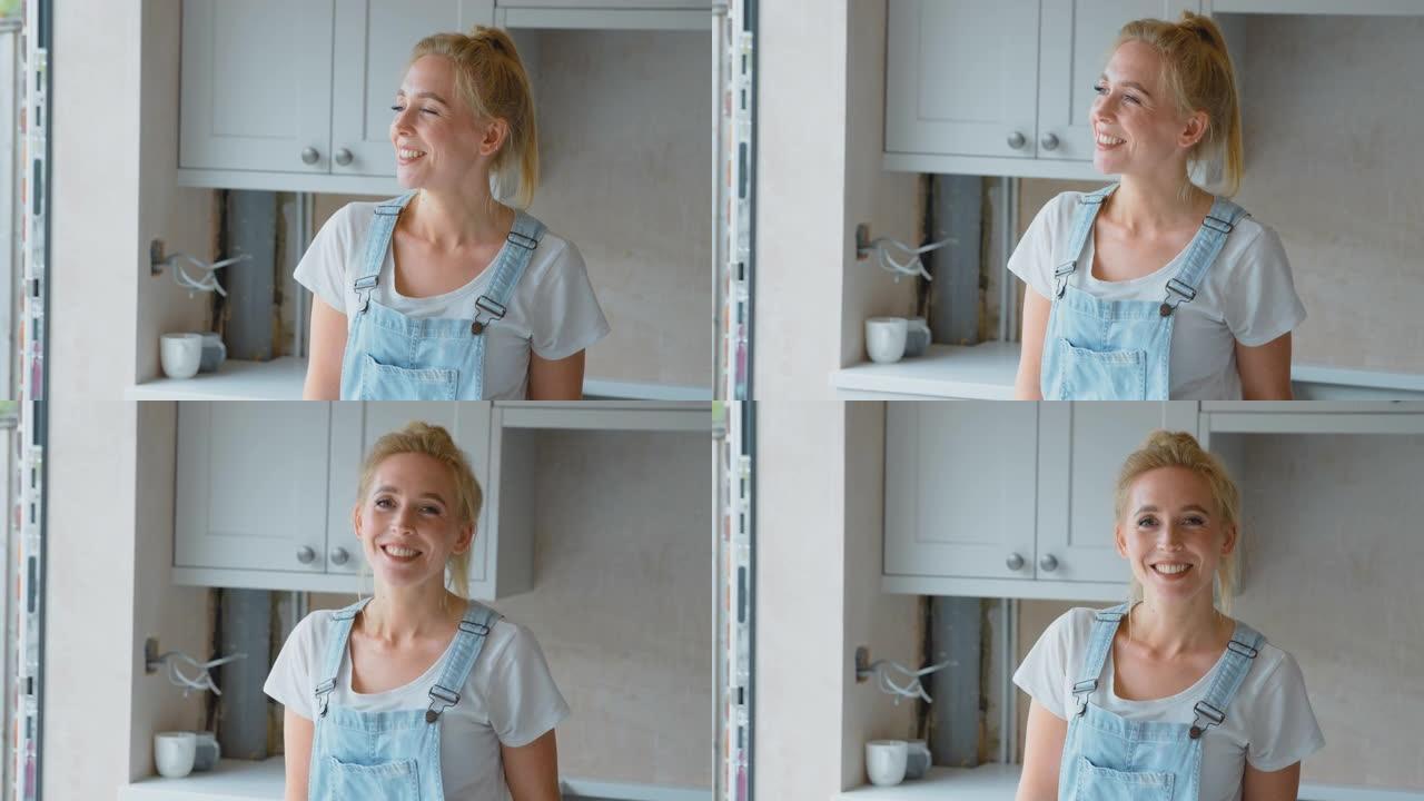 穿着工作服的微笑女人的肖像在家里翻新厨房-慢动作拍摄