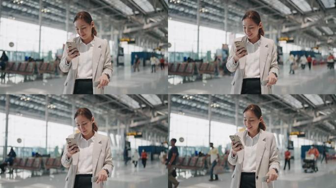 微笑的年轻亚洲妇女在机场使用智能手机