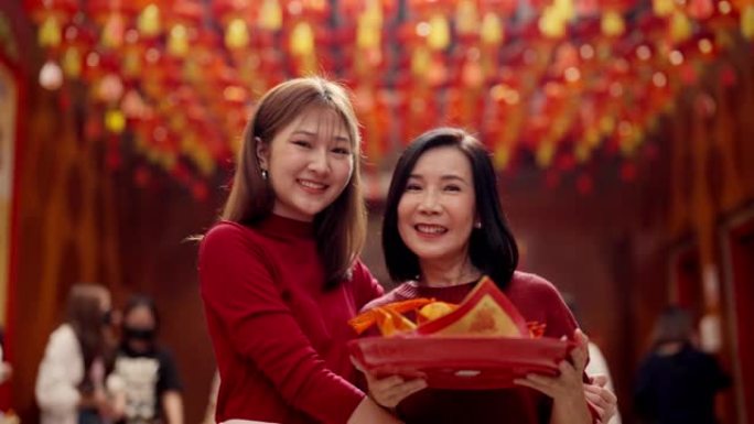 为中国新年祈祷。面对镜头微笑笑容母女两人