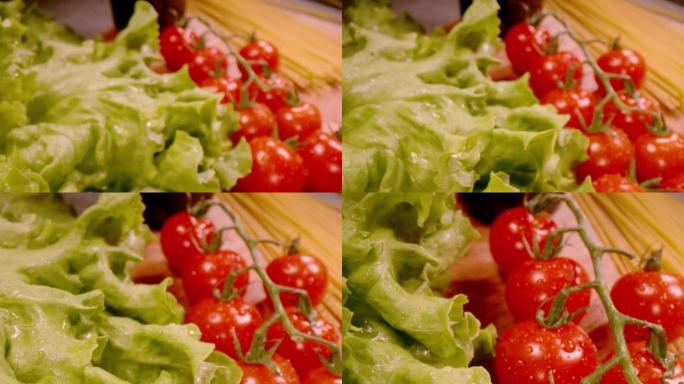 慢动作，特写: 水滴中的新鲜绿色生菜和红色西红柿