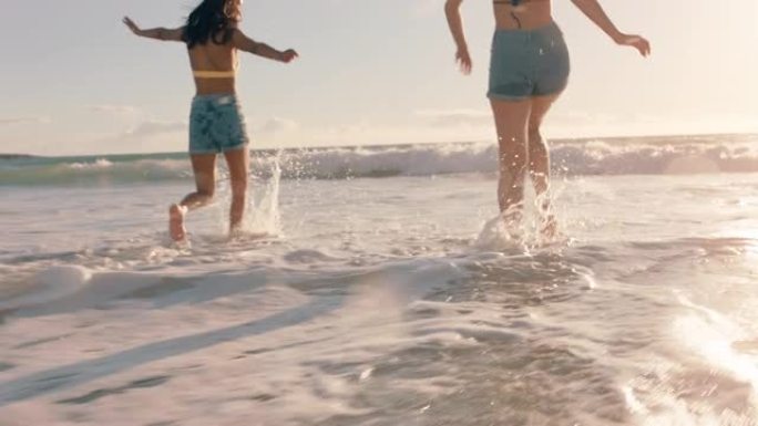 海滩上的女朋友互相泼洒海水，在温暖的夏日，在海边玩得开心，享受夏日假期