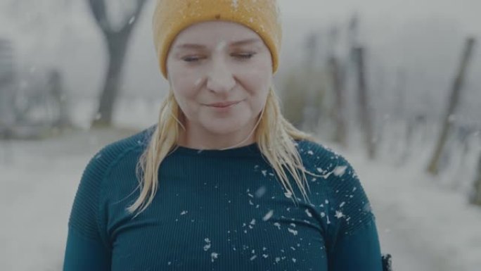 SLO MO肖像，一个女人在雪地里摆姿势时深呼吸