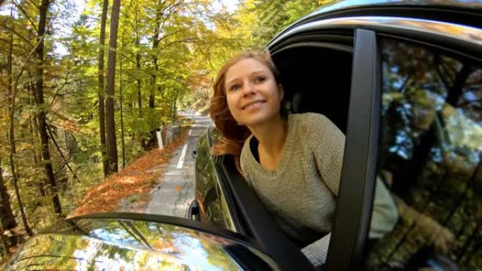 年轻女子享受秋天的公路旅行