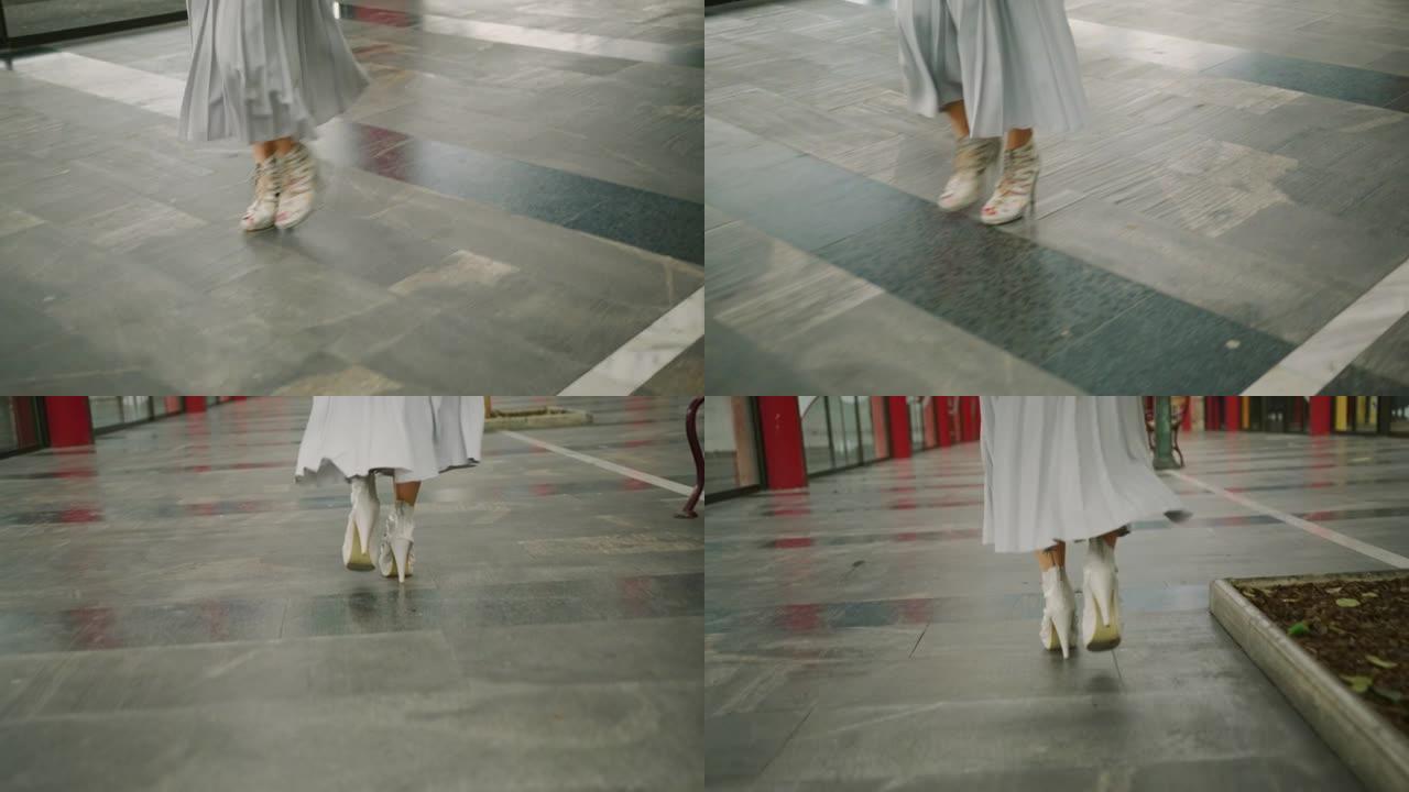 穿着高跟鞋走在购物中心的女人