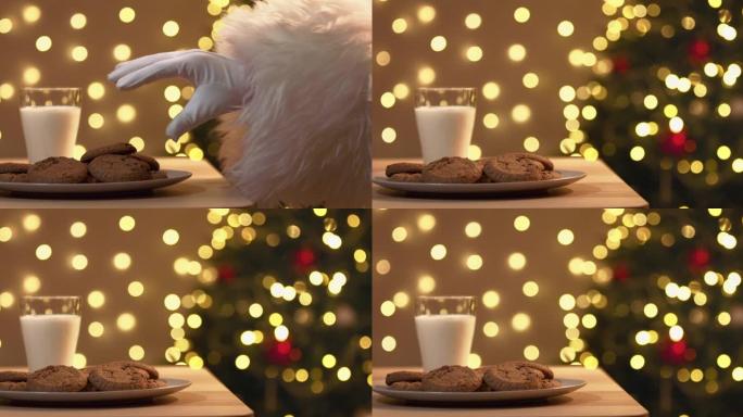圣诞老人戴着白手套的手从盘子里偷饼干的特写镜头。圣诞幽默。
