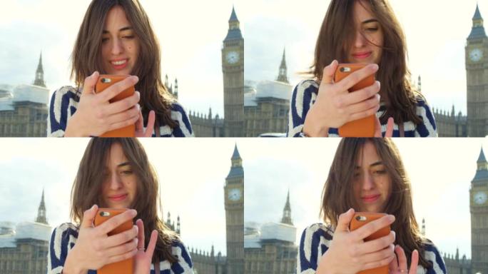 4k视频片段，一名年轻女子在探索伦敦市时使用智能手机