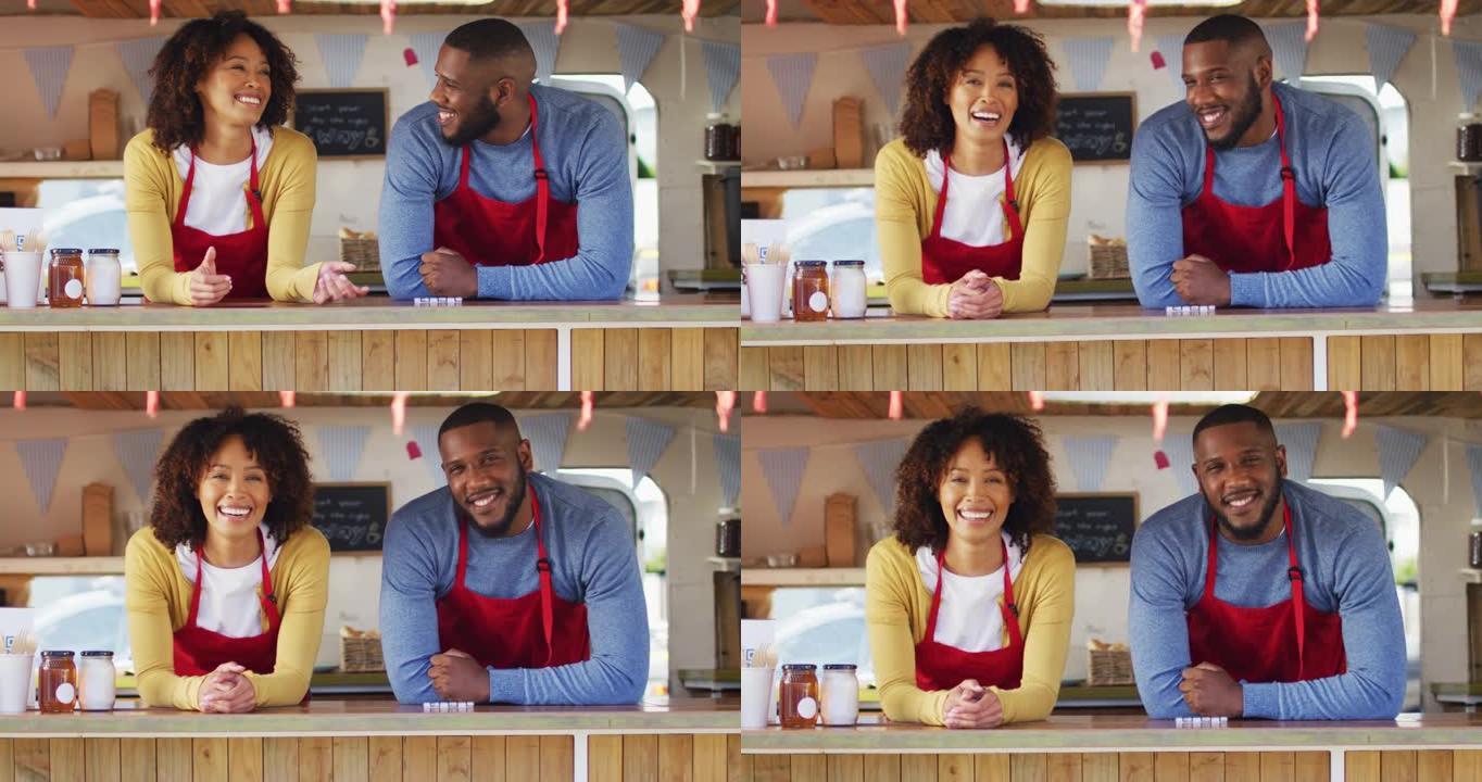 非裔美国夫妇站在餐车上微笑时穿着围裙的肖像