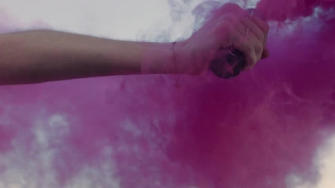特写女子手持粉色烟雾弹在日出时在海滩上跳舞庆祝创意自由