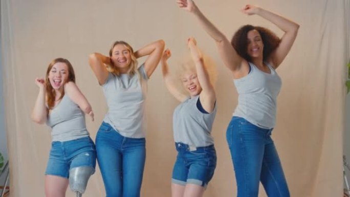 一群穿着随意的女性朋友，一个有假肢，在工作室里促进身体积极微笑和跳舞-慢动作拍摄