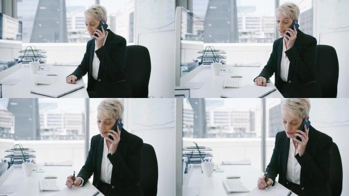 一个成熟的女商人在办公室里用手机说话时写笔记的4k视频片段